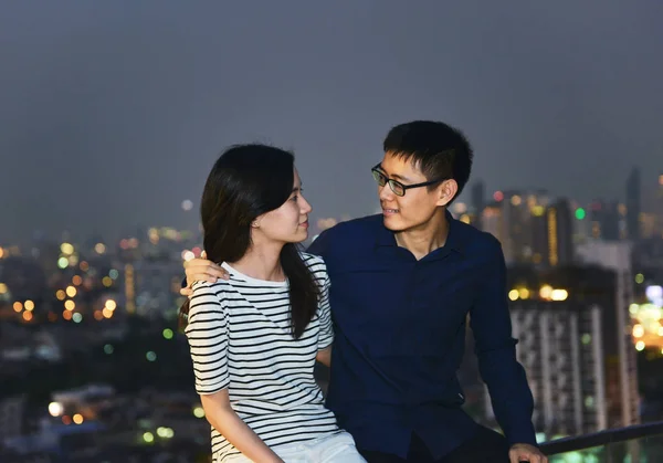Asiatico coppia looking ogni altro su rooftop con città sfondo , — Foto Stock