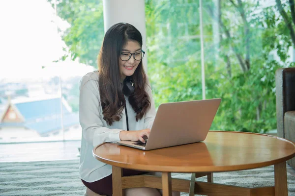 Business Asian girl smiling and using a laptop, person