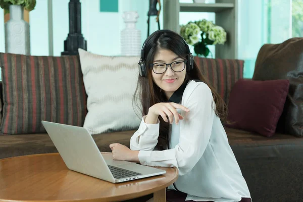 Business Asian girl using a laptop and listening to music, person