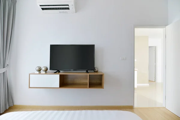 Chambre vide moderne avec tv led sur mur blanc et étagère en bois — Photo