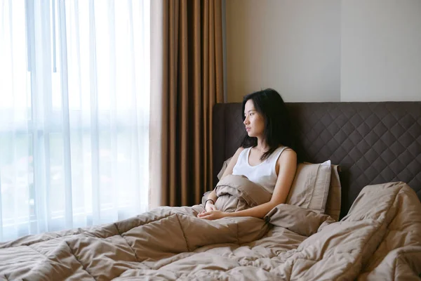 Triste donna depressa pensando sul letto in camera da letto di lusso — Foto Stock