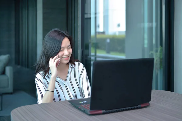 Случайный бизнес Азиатская женщина звонит перед ноутбуком в cond — стоковое фото
