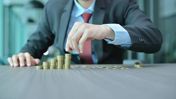 Affärsman stapling mynt i ökande ordning på skrivbord — Stockfoto