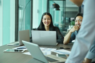 Kullanarak ve iş arkadaşları için konuşurken gülümseyen iş kız 