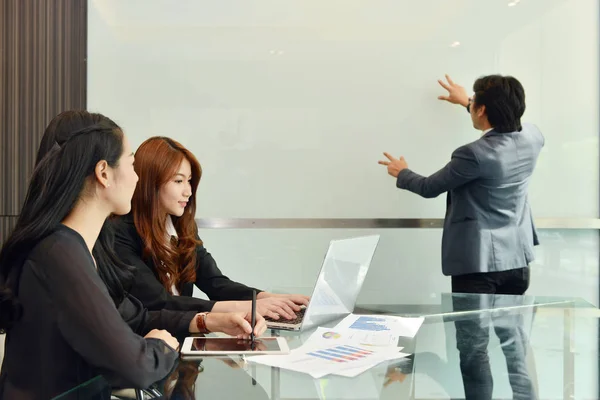 Trabajo en equipo de negocios asiáticos teniendo una reunión con whiteboar en blanco — Foto de Stock