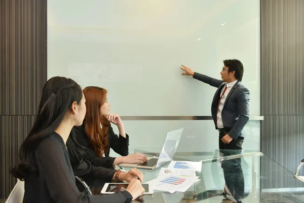 Trabajo en equipo de negocios asiáticos teniendo una reunión con whiteboar en blanco — Foto de Stock