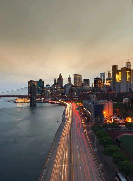 New York City bij zonsondergang met Brooklyn Bridge, Verenigde Staten — Stockfoto