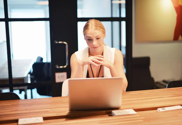 Business blonde girl using a laptop in an office — Stock Photo, Image