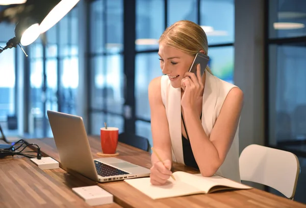Business Blonde Girl Writing a book and phoning in front of a la — Stock Photo, Image