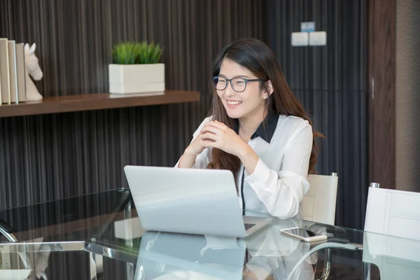 An Asian business woman using laptop in office — Stock Photo, Image