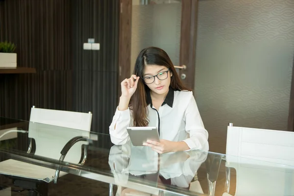 Азиатская деловая женщина, использующая планшет в офисе — стоковое фото