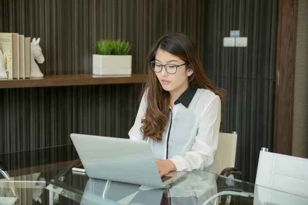 Азиатская деловая женщина, использующая ноутбук в офисе — стоковое фото