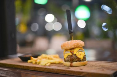 hamburger, patates kızartması ve sosu bir fincan ahşap bir PI için görev yaptı.