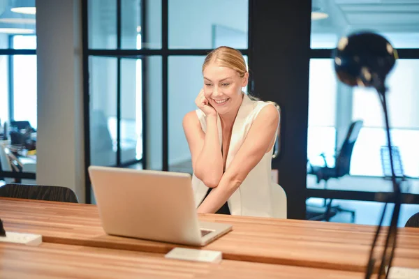 Happy business blonde girl using a laptop in an office — Stock Photo, Image