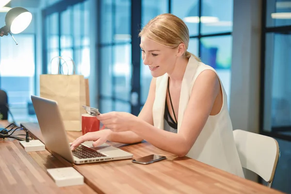 Happy business blonde girl using a credit card on shopping onlin — Stock Photo, Image