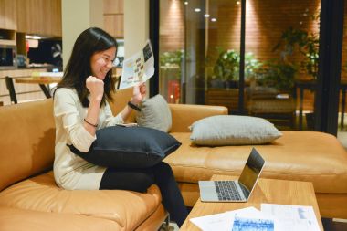 Geceleri oturma odasında bir dizüstü bilgisayar kullanarak mutlu iş kadını