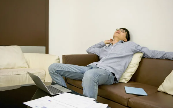 Азіатський бізнесмен, спати на дивані у вітальні на ніч — стокове фото