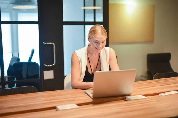 Деловая блондинка с ноутбуком в офисе — стоковое фото