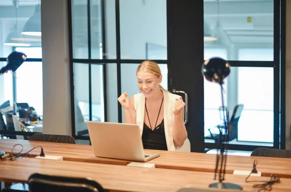 Счастливая деловая блондинка с ноутбуком в офисе — стоковое фото