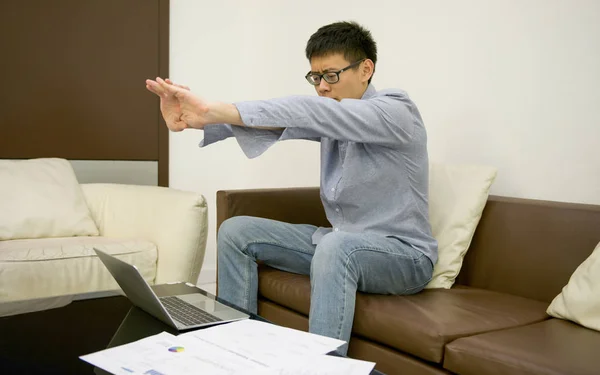 Азіатський бізнесмен розтягування перед ноутбук з документами — стокове фото
