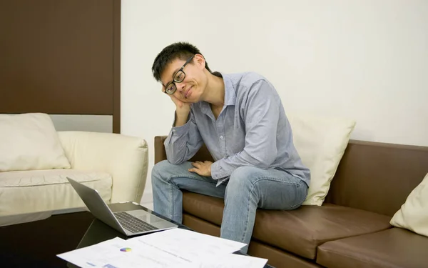Підкреслив азіатських бізнесмен за допомогою смартфона у вітальні на — стокове фото
