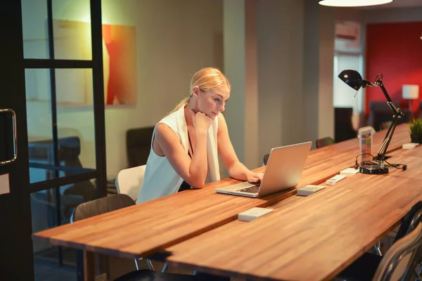 Happy business blonde girl using a laptop in an office — Stock Photo, Image