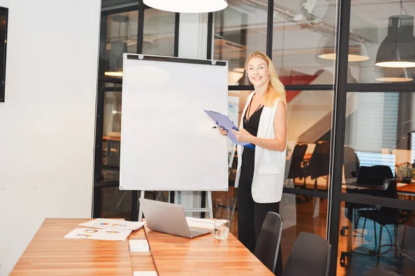 Blonde vrouw zakelijke presentatie van een project op lege whiteboard — Stockfoto