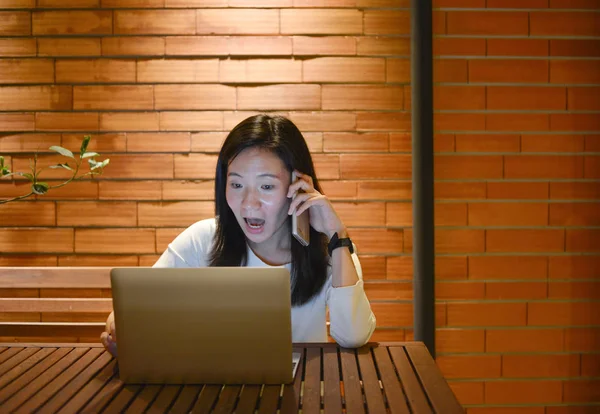 Шокированная азиатка с помощью ноутбука ночью, внештатный работник — стоковое фото
