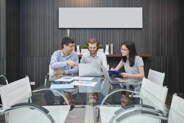 Grupo de empresarios reunidos en una sala de reuniones, compartiendo sus — Foto de Stock