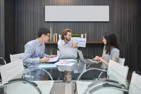 Grupo de empresarios reunidos en una sala de reuniones, compartiendo sus — Foto de Stock