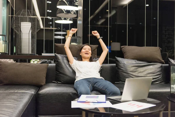 Счастливая азиатская бизнес-леди с ноутбуком в гостиной рядом — стоковое фото