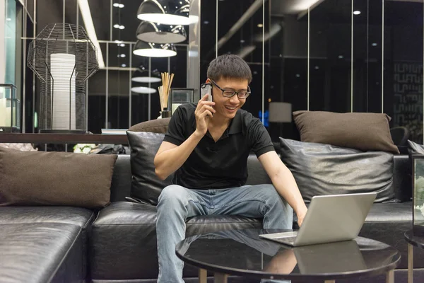 Happy businessman using laptop in living room at night