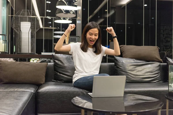 Счастливая бизнесвумен, использующая ноутбук в гостиной ночью — стоковое фото