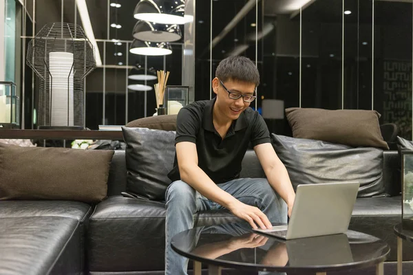 Щасливий бізнесмен використовує ноутбук у вітальні вночі — стокове фото