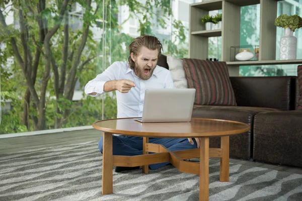 Напружений західний бізнесмен використовує ноутбук у вітальні — стокове фото