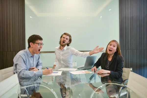 Blonde business man slapping Asian employee in meeting room