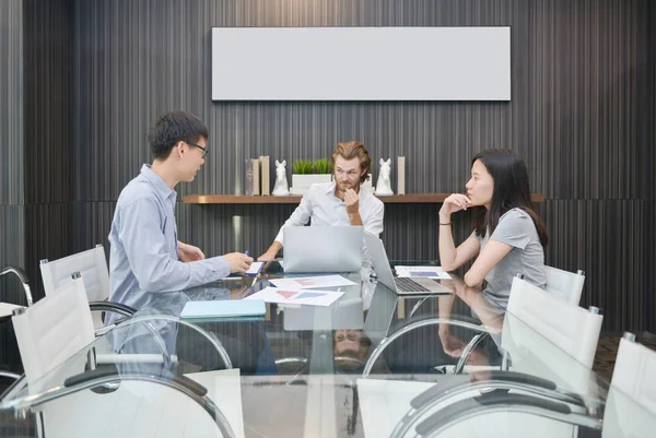 Grupo de empresarios reunidos en una sala de reuniones, compartiendo sus — Foto de Stock