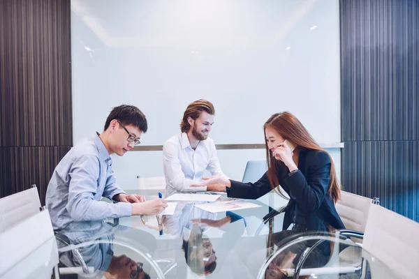 Grupo de empresarios reunidos en una sala de reuniones, compartiendo sus — Foto de Stock