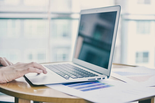 Close up hand touching a laptop in business concept with free sp