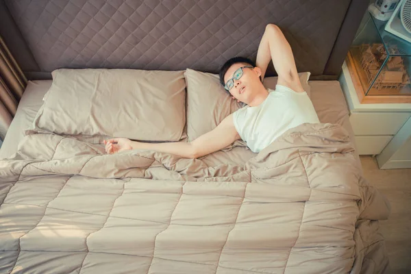 Depresso asiatico uomo colpa su il telefono su letto — Foto Stock