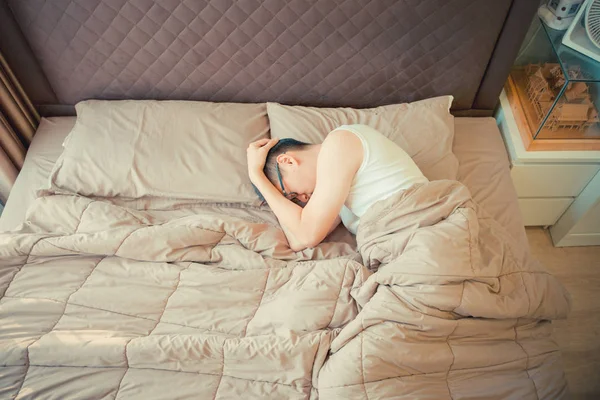 Depressief Aziatische man schuld te geven op de telefoon op bed — Stockfoto