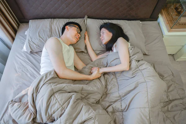 Šťastný asijský pár v lásce, spí spolu na posteli — Stock fotografie