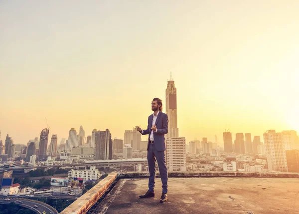 Homme d'affaires occidental regardant Bangkok ville au coucher du soleil — Photo