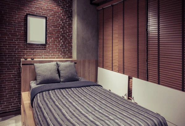 Chambre loft avec lit près du mur de briques et rideau en bois — Photo