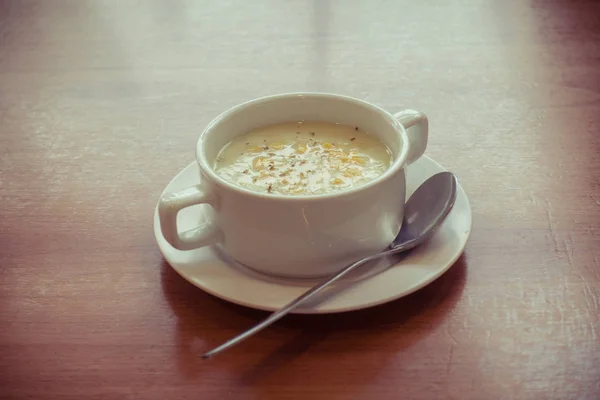 Zupa z kukurydzy w biały kubek na stole na białym tle — Zdjęcie stockowe