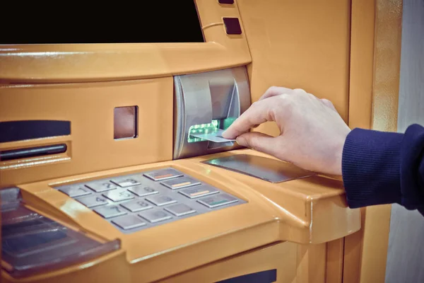 Primo piano della mano della donna che inserisce la carta di debito in un bancomat — Foto Stock