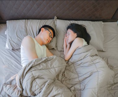 Asya çift yatak odasında kahverengi yatakta uyuyor