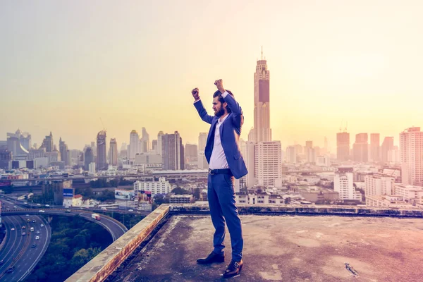 Exitoso empresario occidental con las manos en alto mirando a la ciudad — Foto de Stock