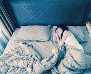 Asyalı kadın yatağın üstüne battaniye, en iyi görünümü ile uyku