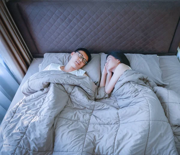 Asijské pár spí na posteli v ložnici, špičkové zobrazení — Stock fotografie